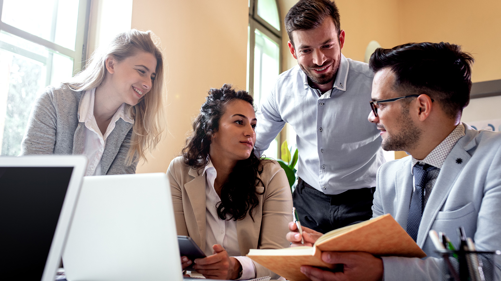 coworkers gathered around a laptop