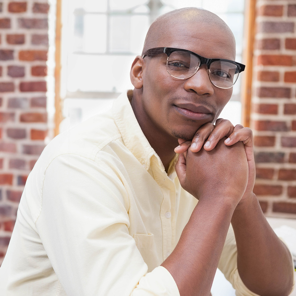 man with bald head and glasses with folded hands